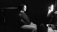 Standbild des Case-Videos: Die Darstellerin bei den Dreharbeiten im Studio mit Kopfhalterung