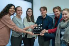 eyecatcher Geschäftsführer Richard Klein, Frau Prof. Dr. Andrea Gschwendtner (2. v.r.) sowie vier Studentinnen der HS RheinMain halten gemeinsam eine Filmklappe